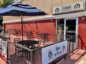 Great outside patio area at 7 Leguas Mexican Grille with tables, umbrellas, and signage